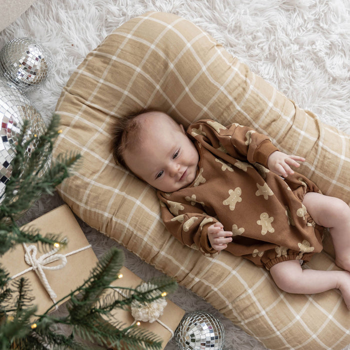 Baby lying on Brixton Phoenix Muslin Changing Pad Cover - Nutmeg Plaid