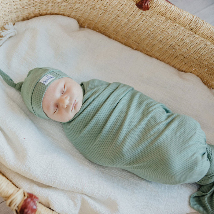 Baby sleeps wrapped in Copper Pearl Rib Knit Swaddle Blanket - Clover
