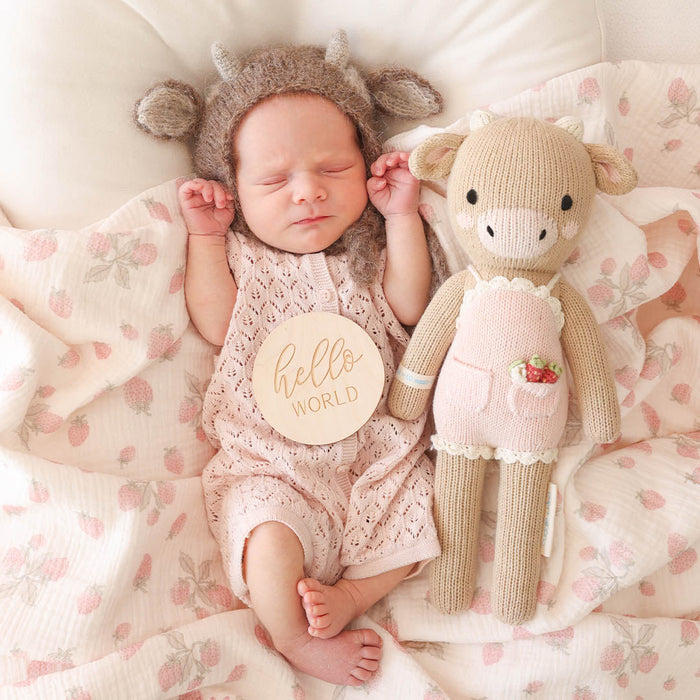 Newborn baby lying next to Cuddle and Kind Ava the Cow - Powder Pink