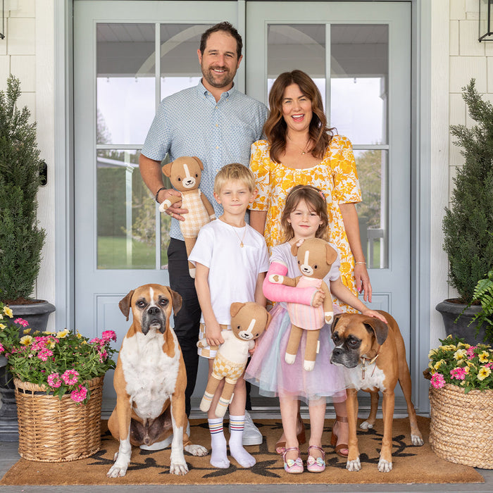 Jillian Harris's family standing in front of home while son holds Cuddle and Kind George the Dog