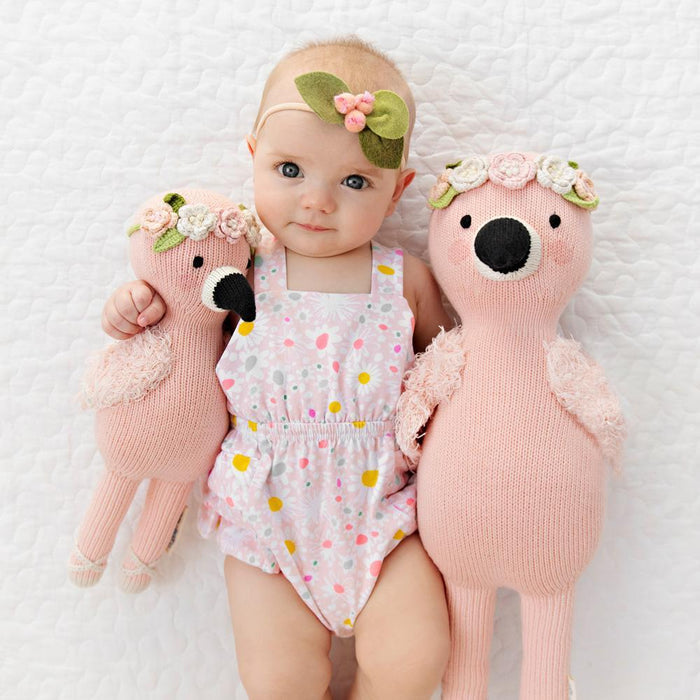 Baby with arms around Cuddle and Kind Penelope the Flamingo