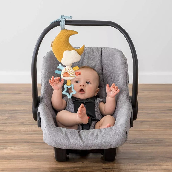 Baby sitting in carseat plays with Itzy Ritzy Bitzy Notes - Musical Pull Down Toy - Cloud/Sun