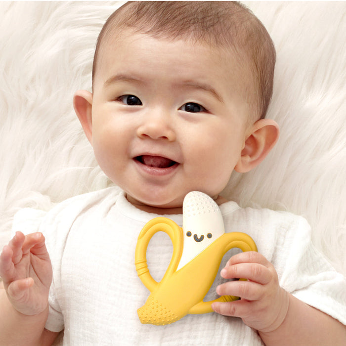 Baby playing with Itzy Ritzy Chew Crew Silicone Handle Teether - Banana