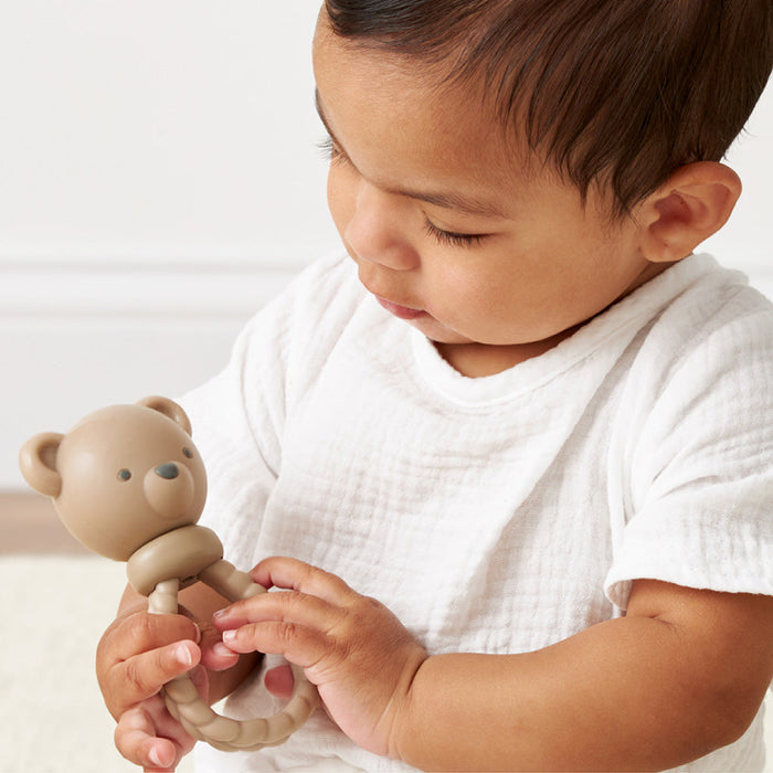 Baby looks at Itzy Ritzy Sweetie Rattle - Theo the Bear