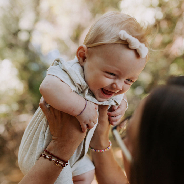 Baby wearing Joyful Bead Company Dahlia Purple Bracelet