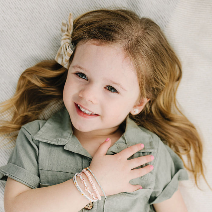 Little girl wears Joyful Bead Company Petal Pink Flower Bracelet - Gold