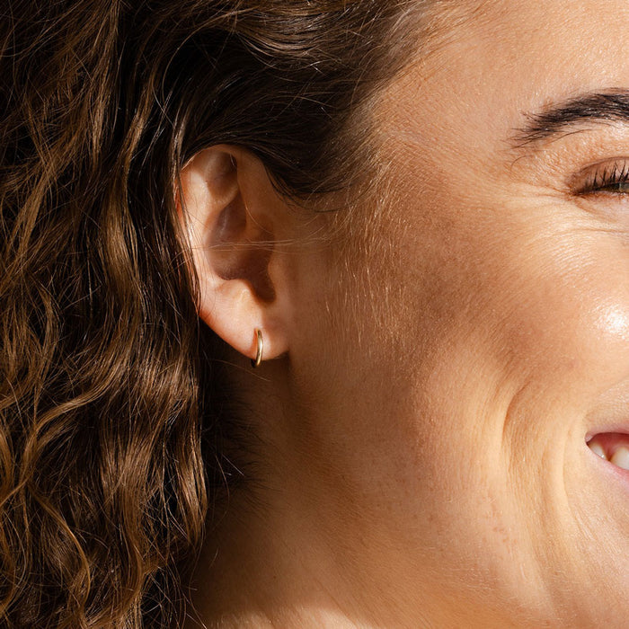 Woman smiles while wearing Made by Mary Gold Filled Mini Live In Hoop Earrings - Gold