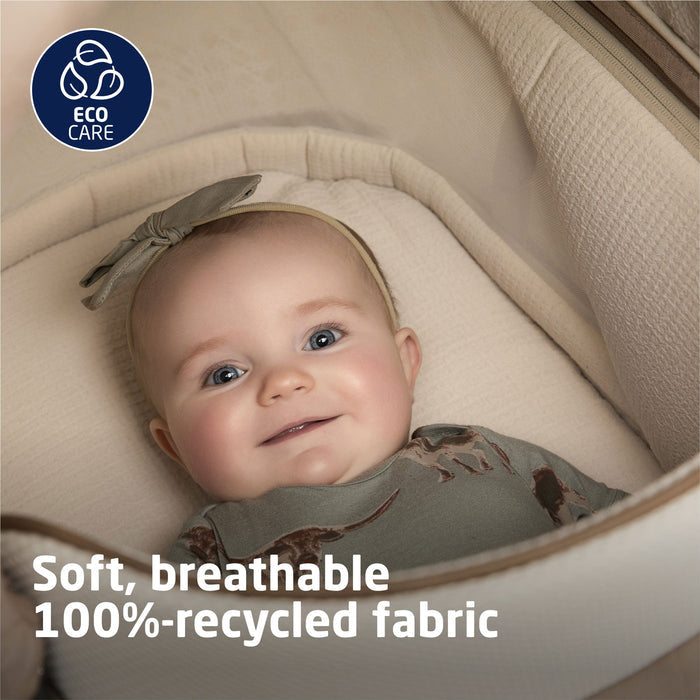 Baby girl lying in Maxi-Cosi Carriage Accessory - Natural Heritage