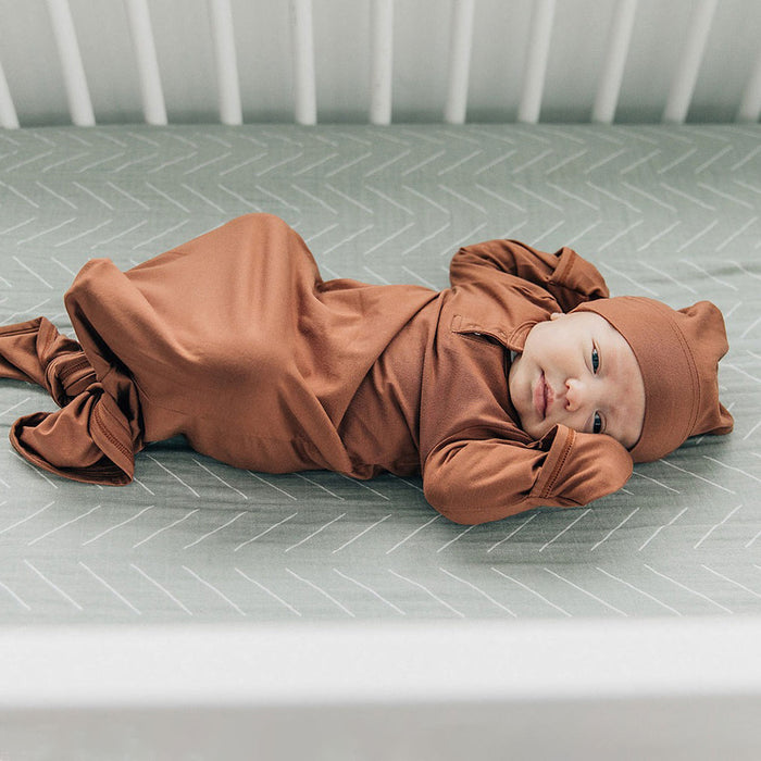 Baby lying on Mebie Baby Muslin Crib Sheet- Desert Sage