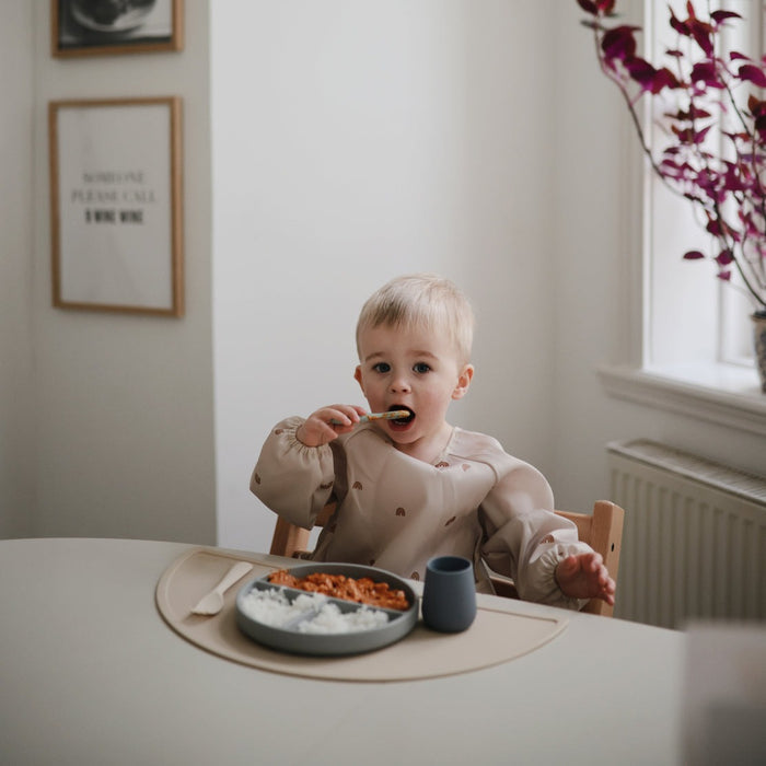 Toddler eating dinner with Mushie First Feeding Baby Spoons 2-Pack - Cambridge Blue / Shifting Sand