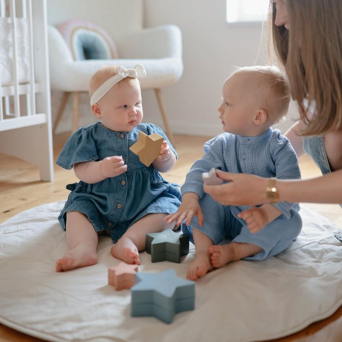 Babies play with Mushie Nesting Toy - Stars - Retro
