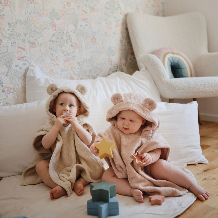 Babies in bath robes play with Mushie Nesting Toy - Stars - Retro