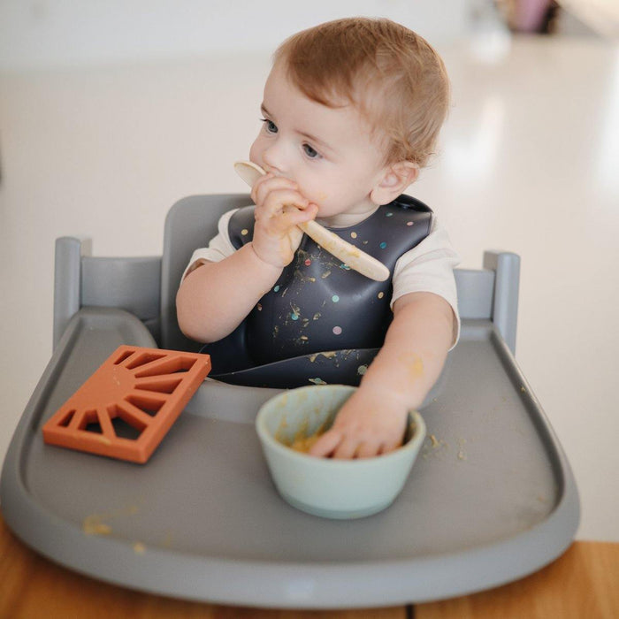 Toddler eating food with Mushie Silicone Feeding Spoons - 2 Pack