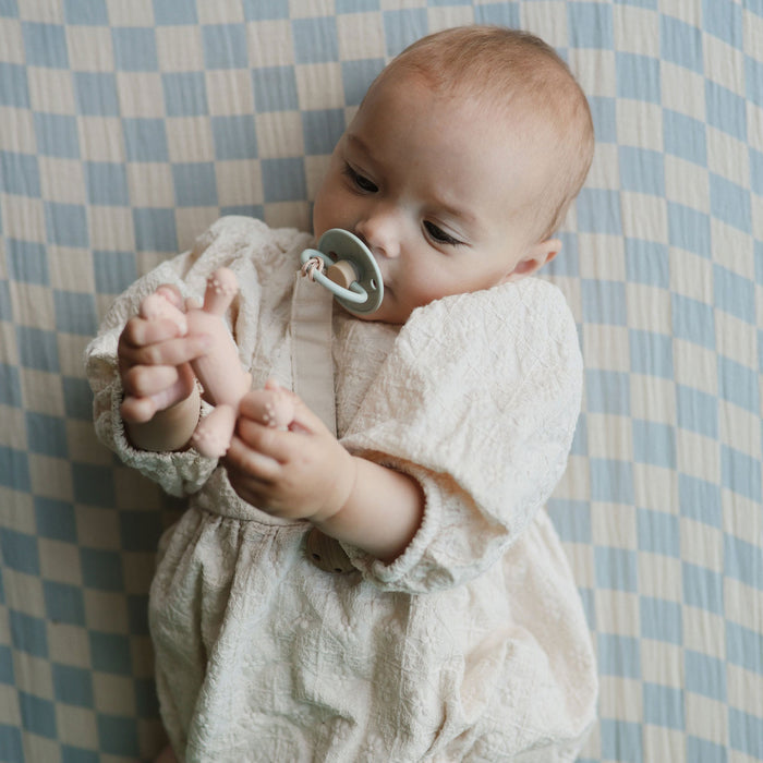 Baby plays with Mushie Unicorn Figurine Teether - Blush