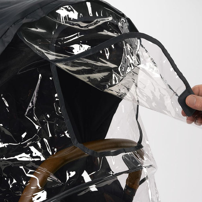 Parent using Nuna TRIV Series Rain Cover - Black and Clear