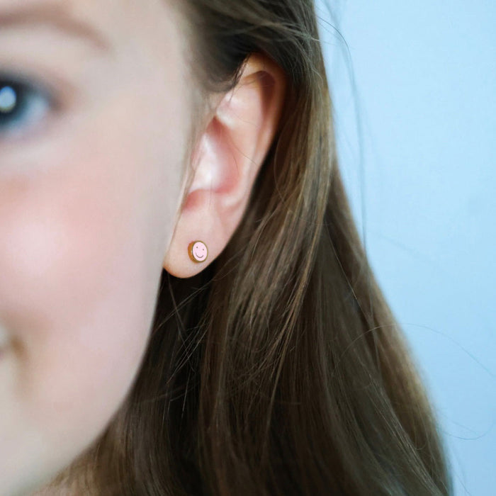 Little girl wearing Pierced Co Tiny Smiley Screw Back Child Earrings - Pink