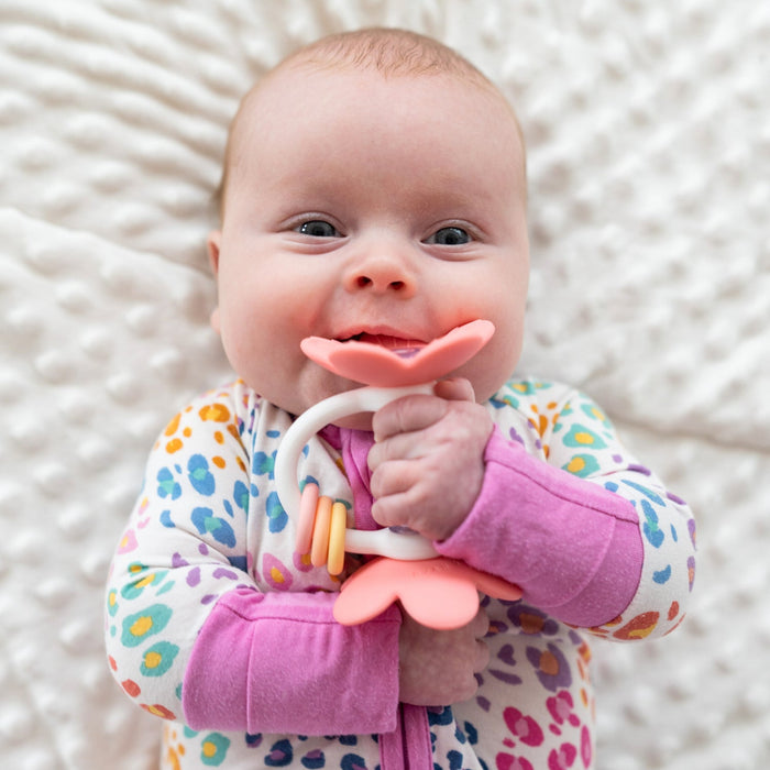Baby girl chews on Ryan and Rose Flower Teether Rattle Toy - Shortcake