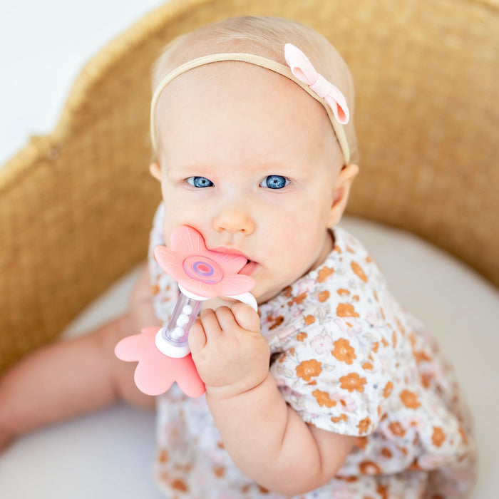 Baby girl chews on Ryan and Rose Flower Teether Rattle Toy - Shortcake
