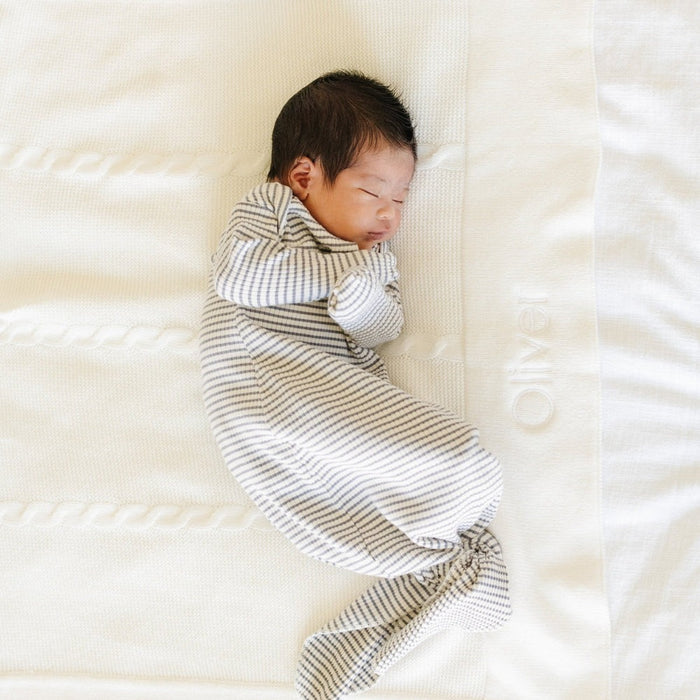 Baby lying on Saranoni Heirloom Cotton Knit Receiving Blanket - Cream