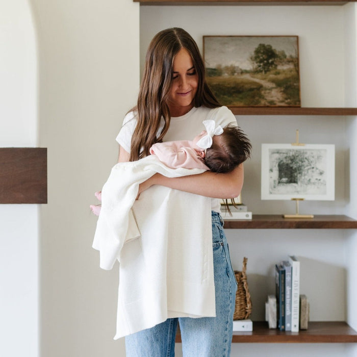 Mom holds baby wrapped in Saranoni Heirloom Cotton Knit Receiving Blanket - Cream