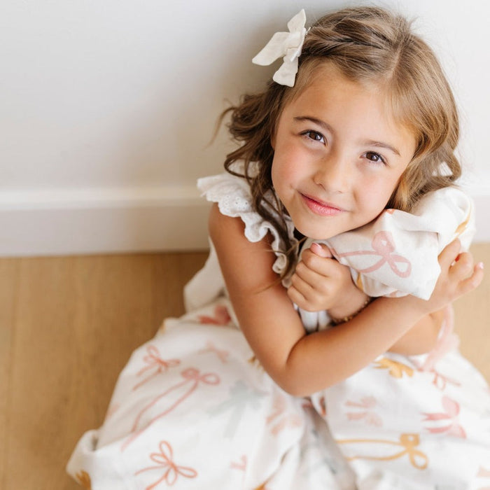 Little girl snuggles Saranoni Receiving Minky / Lush Blanket - Bows