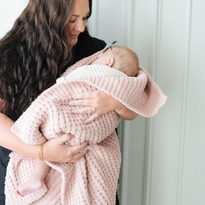 Mom holds sleeping baby wrapped in Saranoni Receiving Waffle Knit Blanket - Rosette