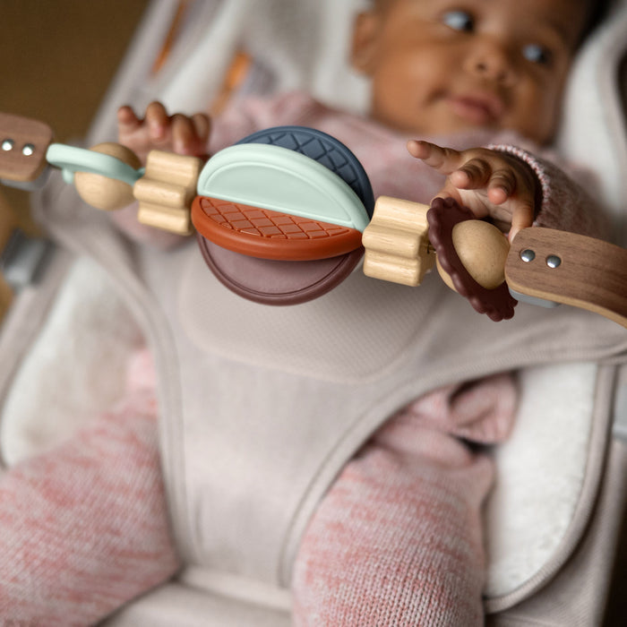 Baby sitting in MIRA bouncer playing with UPPAbaby Wonder Wheel Toy Bar - MIRA accessory attached